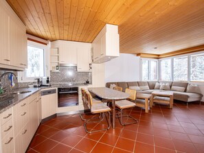 A modern kitchen with granite countertops, a built-in oven, and a dining area with a table and chairs. - Tschopp, (Samnaun-Compatsch) by Interhome (Samnaun)