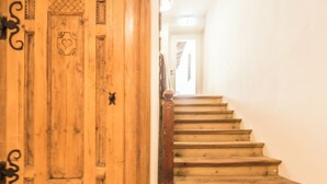 En trætrap med gelænder, der fører op til en dør med et hjerte- og katte-design.