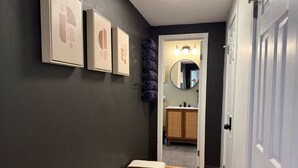 Ein Flur mit einer Bank, einem Spiegel und gerahmten Bildern an der Wand.