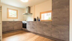 Une cuisine moderne avec des meubles en bois, un four encastré et une fenêtre.
