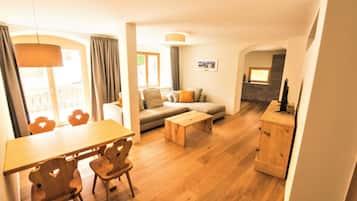 Ein modernes Wohnzimmer mit einer Couch, einem Couchtisch, einem Holzesstisch und Stühlen.