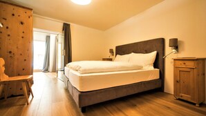 Une chambre à coucher avec un lit, une armoire en bois et un bureau.