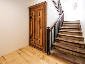 A wooden staircase with a handrail and a wooden door with a cat symbol. - Appartements Münsterhof, (Müstair) by Interhome (Müstair)