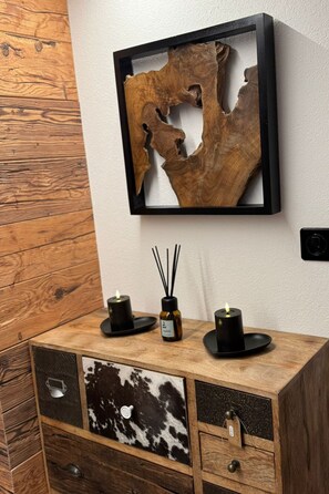 Un mueble de madera con cajones y una obra de arte que representa una textura de madera.