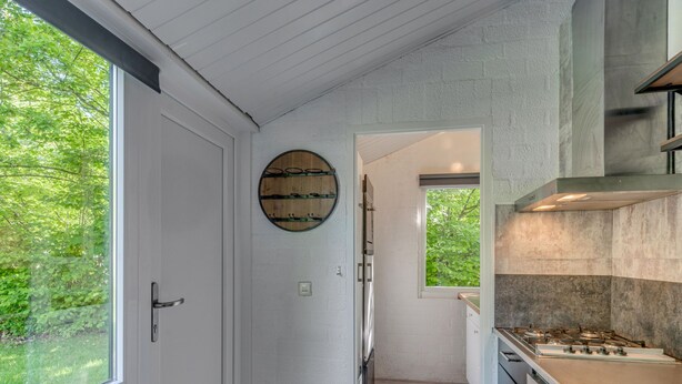 Una cocina con un ventanal grande, una decoración de barril de madera y una estufa moderna.
