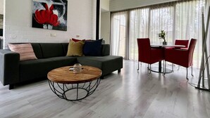 Una sala moderna con un sofá, una mesa de centro y sillas rojas.