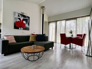 Ein modernes Wohnzimmer mit einer Couch, einem Couchtisch und roten Sessel.