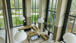 A spacious room with large windows, a sectional sofa, and pendant lighting. - Unique Bosco Verticale Apartment: Live in the World's Icon (Milano)