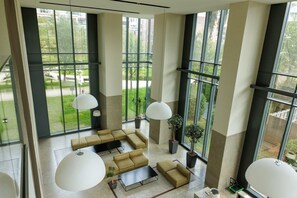 A spacious room with large windows, a sectional sofa, and pendant lighting. - Unique Bosco Verticale Apartment: Live in the World's Icon (Milano)