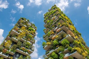 Deux immeubles de grande hauteur dotés de balcons couverts de verdure.