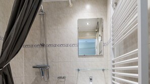 Ein Badezimmer mit einer Badewanne, einem Waschbecken, einer Toilette und einer Dusche.