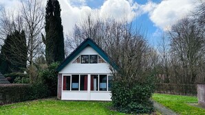 Ein zweistöckiges Haus mit Giebeldach, einer Veranda und einem Weg zum Eingang.