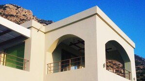 Un edifici modern de dues plantes amb teulada plana, grans finestres i un balcó.