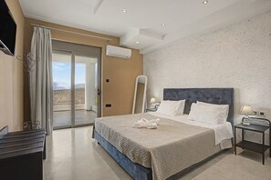 Een hotelkamer met een groot bed, uitzicht door een schuifdeur, een flatscreen televisie en een airconditioning.