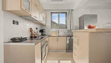 A modern kitchen with a built-in dishwasher, a toaster, and a window with a view of the outdoors.