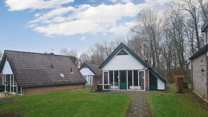 Um imóvel residencial com calçada pavimentada, gramado e garagem separada.