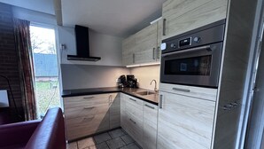 Eine moderne Küche mit Backofen, Kaffeemaschine und Spüle.