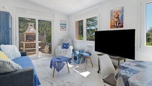 A spacious living room with a fireplace, a television, and a cozy seating area. - Villa “My Little Castle Platja D'Aro” with Sea View, Balcony and Wi-Fi (Castell d'Aro)