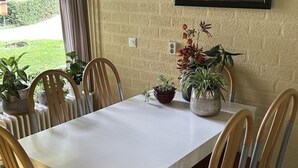 A dining table with chairs, potted plants, and a radiator. - Bungalowpark Simpelveld - Alpha 89 by Interhome (Simpelveld)