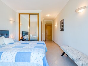 A bedroom with a bed, bedside table, lamp, and a bench. - Fairviews Village - Boavista Resort in Lagos by Interhome (Lagos)