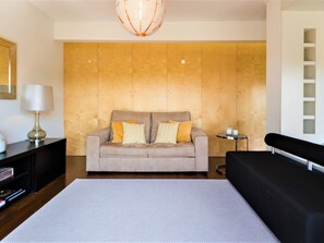 A modern bedroom with a large bed, a sofa, a small side table, and a lamp. - Apartment  by Interhome (Quarteira)
