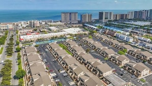 A coastal urban area with high-rise buildings, a marina, and a residential complex with parking. - Villa Condo with Amenities and Short Beach Walk (Ocean City)
