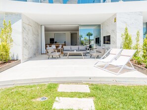 A modern outdoor living area with a sofa, chairs, and a table. - Apartment  by Interhome (Albufeira)