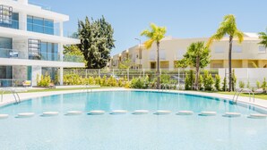 A swimming pool with a clear blue water surface, surrounded by a white tiled deck. - Apartment  by Interhome (Albufeira)