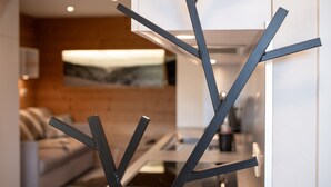 A modern interior with a minimalist design, featuring a sofa, a coffee table, and a decorative metal sculpture. - Duplex Cottage Between Lake and Mountains in the High Vosges (Saulxures-sur-Moselotte)