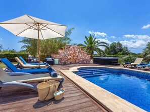 A poolside area with lounge chairs, a stone wall, and a small pool. - Can Molino by Interhome (Cala Figuera)
