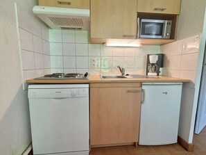 A compact kitchen with a Bosch dishwasher, a microwave, a coffee maker, and a sink. - Skiing, terrace, swimming pool: ideal apartment (Flumet)
