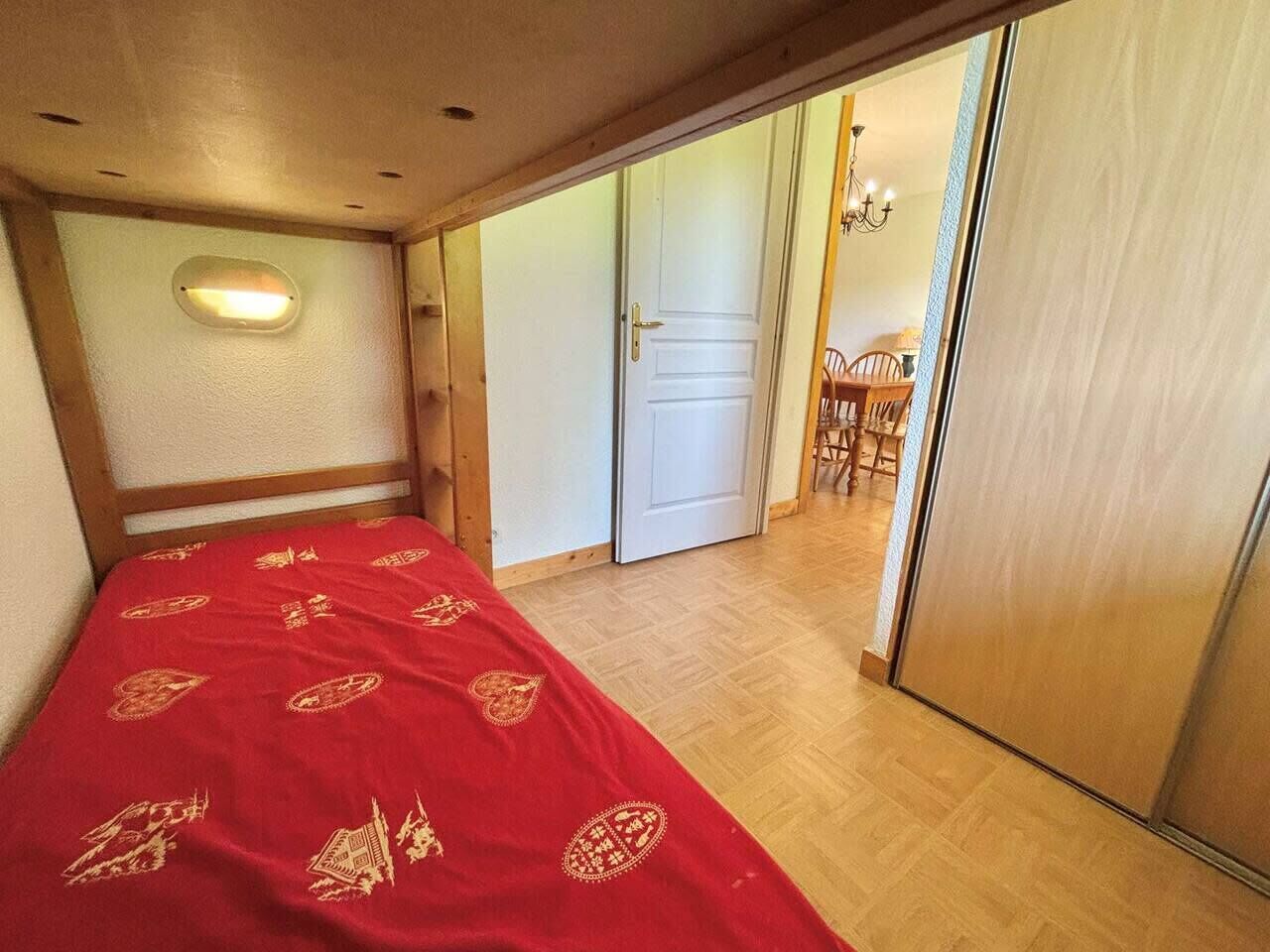 A room with a bed, a door, and a small table with chairs.