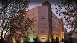 A multi-story building with a corner entrance, a flat facade, and a series of windows. - Cadi Palace (Mar del Plata)