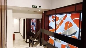 A hallway with a wooden floor, a staircase, and a wall with abstract art. - Cadi Palace (Mar del Plata)