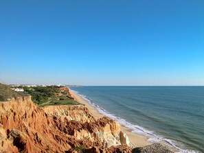 A coastal landscape with a beach, cliffs, and a distant cityscape. - Vale do Lobo Apartment D by Interhome (Vilamoura)