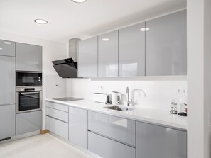 A modern kitchen with stainless steel appliances, a built-in oven, a microwave, a toaster, and a sink. - Lagos town centre apartment by Interhome (Lagos)