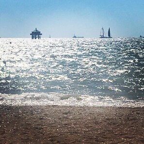 A beach with a pier and sailboats in the distance. - Studio with terrace in the old port of La Rochelle (La Rochelle)