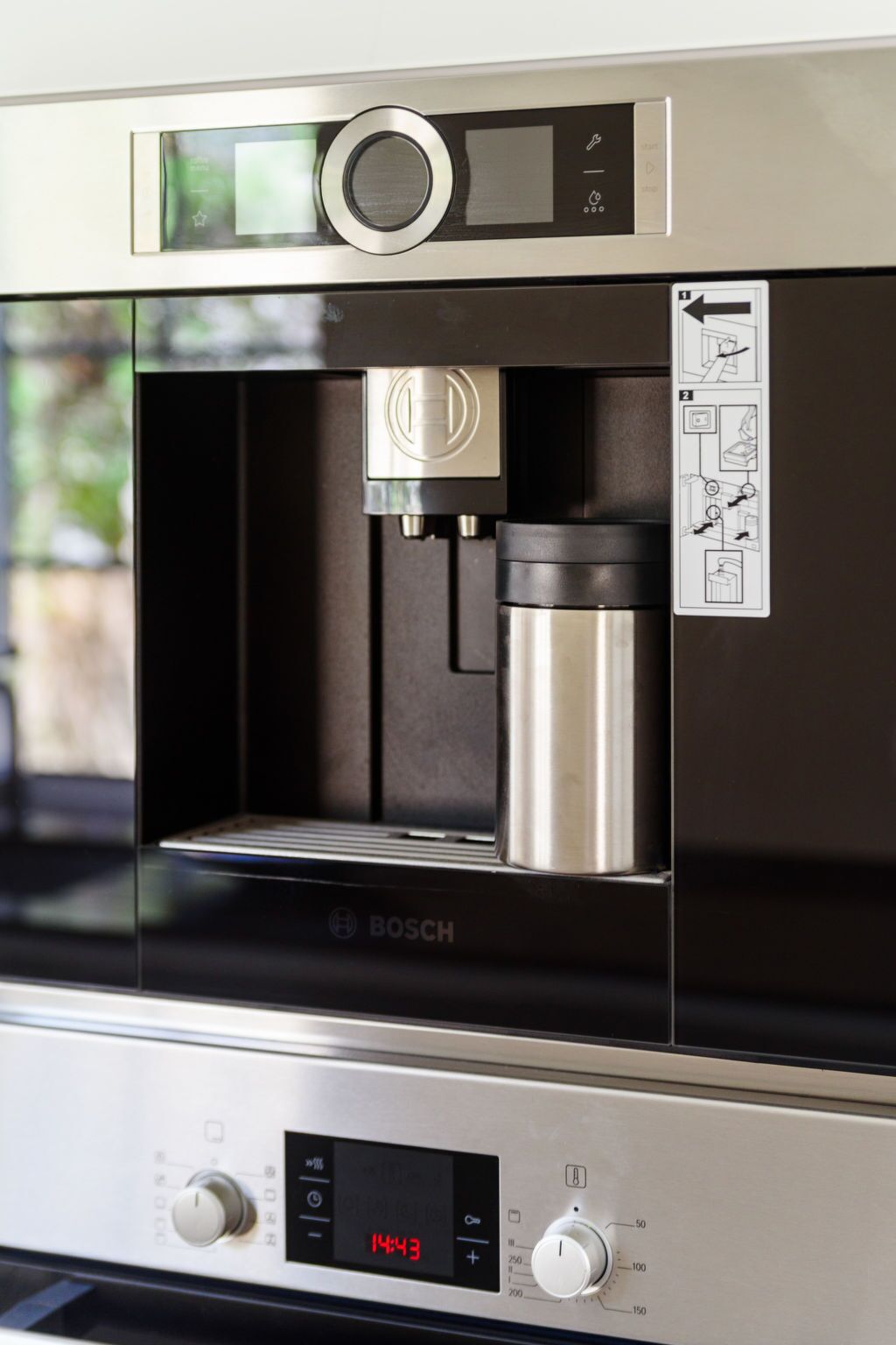 A Bosch coffee machine with a digital display, a coffee pot, and a water reservoir.