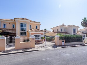 A residential property with a gated entrance, a paved driveway, and a clear sky. - Casa Lago - Varandas do Lago by Interhome (Almancil)