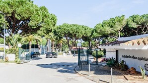 Straßenansicht mit einem Gebäude mit der Aufschrift 'aldela das acoelhas' und einem Parkplatz mit Autos.