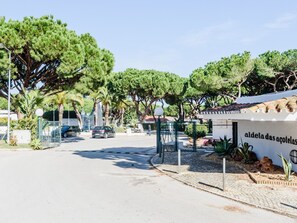 A street view with a building labeled 'aldela das acoelhas' and a parking area with cars. - Apartment  by Interhome (Albufeira)