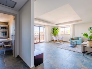 A modern living room with a dining area, kitchen, and large windows. - Apartment  by Interhome (Albufeira)