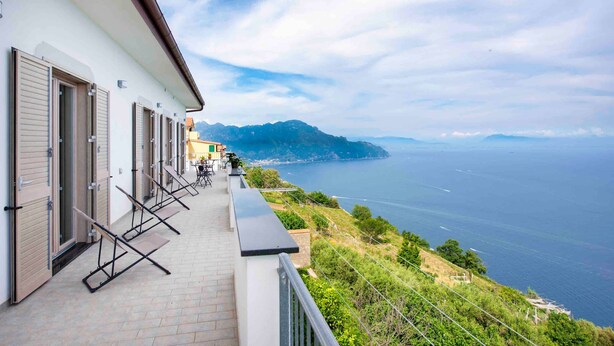 Un hotel sul mare con un balcone vista oceano, un percorso pedonale e una vista sulla costa.