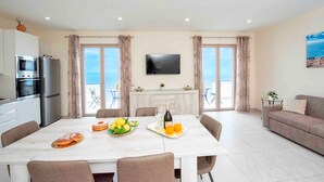 Una cucina moderna con zona pranzo, televisione a schermo piatto e balcone con vista.
