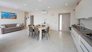 Una cucina moderna con zona pranzo, un divano e un quadro appeso al muro.