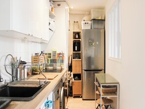 Eine moderne Küche mit einem Edelstahl-Kühlschrank, einer Spüle und einer Holzarbeitsplatte.