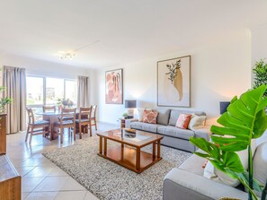A modern living room with a dining area, a sofa set, and artwork on the walls. - Apartment  by Interhome (Vilamoura)