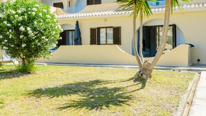 A building with a flat roof, multiple balconies, and a palm tree in the foreground. - Apartment  by Interhome (Carvoeiro (Algarve))