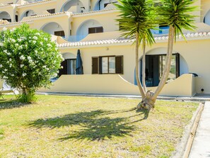 A building with a flat roof, multiple balconies, and a palm tree in the foreground. - Apartment  by Interhome (Carvoeiro (Algarve))