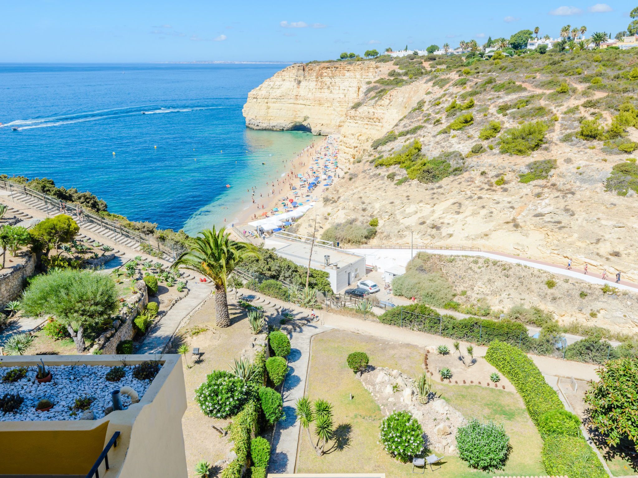 A coastal resort with a beach, cliffside views, and a landscaped garden.